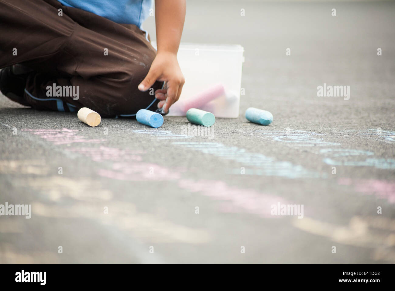 Boy Drawing on Sidewalk with Chalk Stock Photo