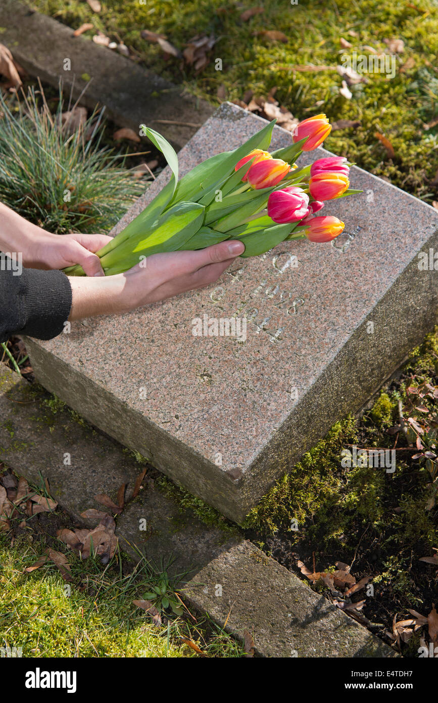 People placing flower gravesite hires stock photography and images Alamy