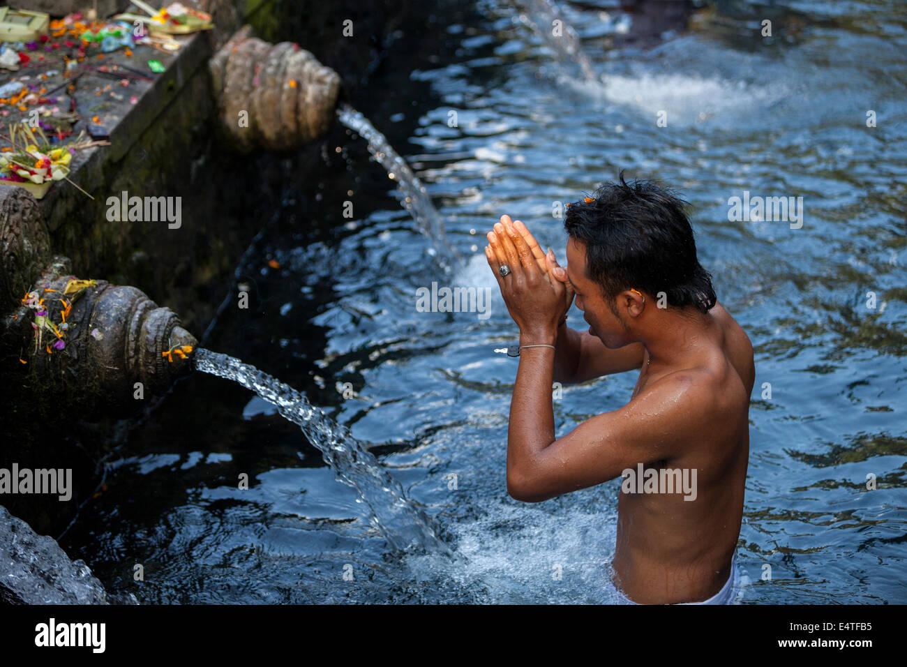 Bali, Indonesia.  Young Man Praying at Tirta Empul, a Spring Sacred to Balinese Hindus. Stock Photo
