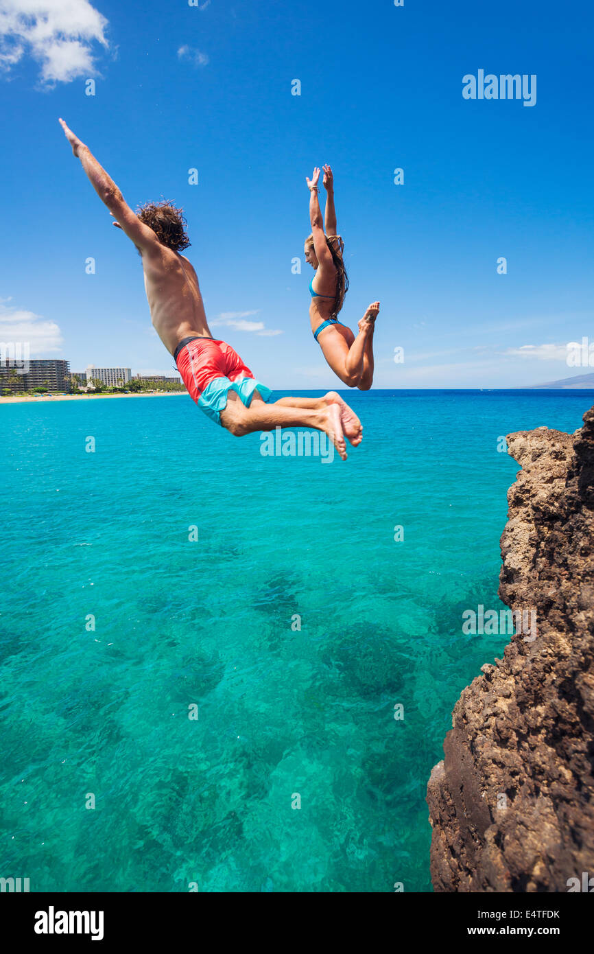 Summer fun, Friends cliff jumping into the ocean. Stock Photo