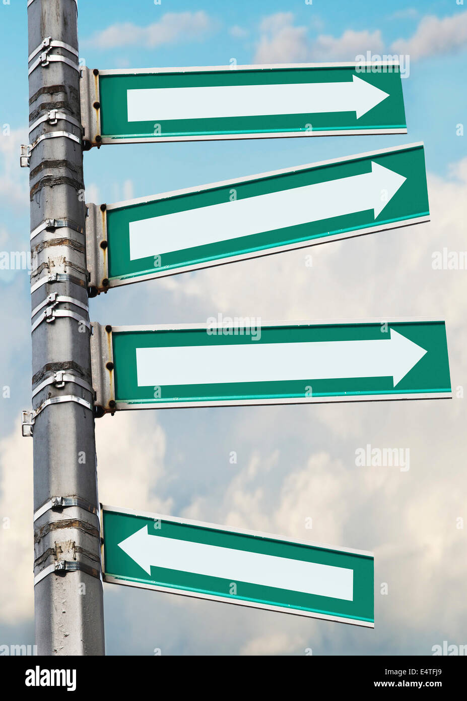 Arrow signs on a pole, showing different directions against sky Stock Photo