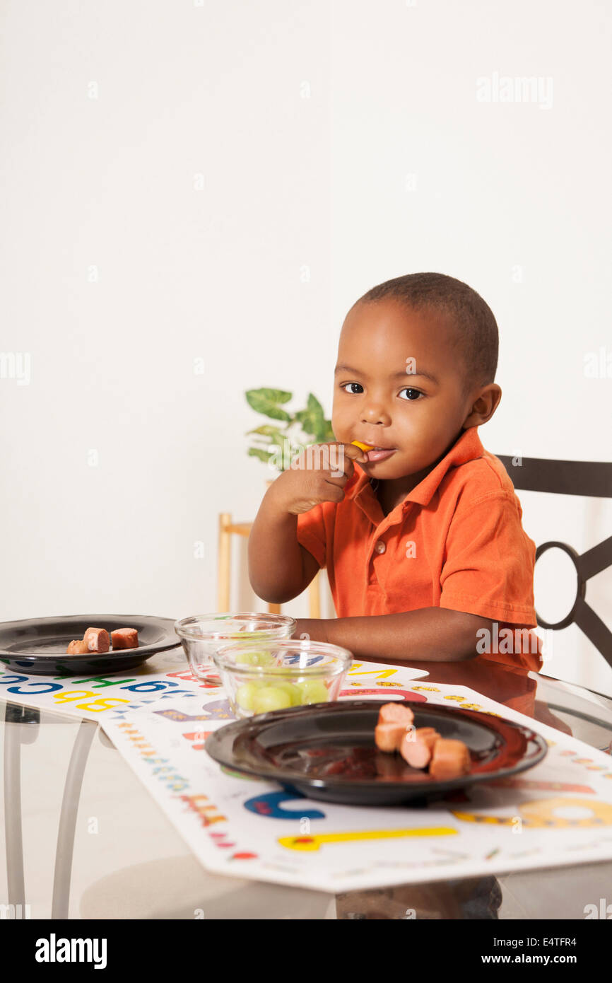 Boy Eating Lunch at Kitchen Table Stock Photo
