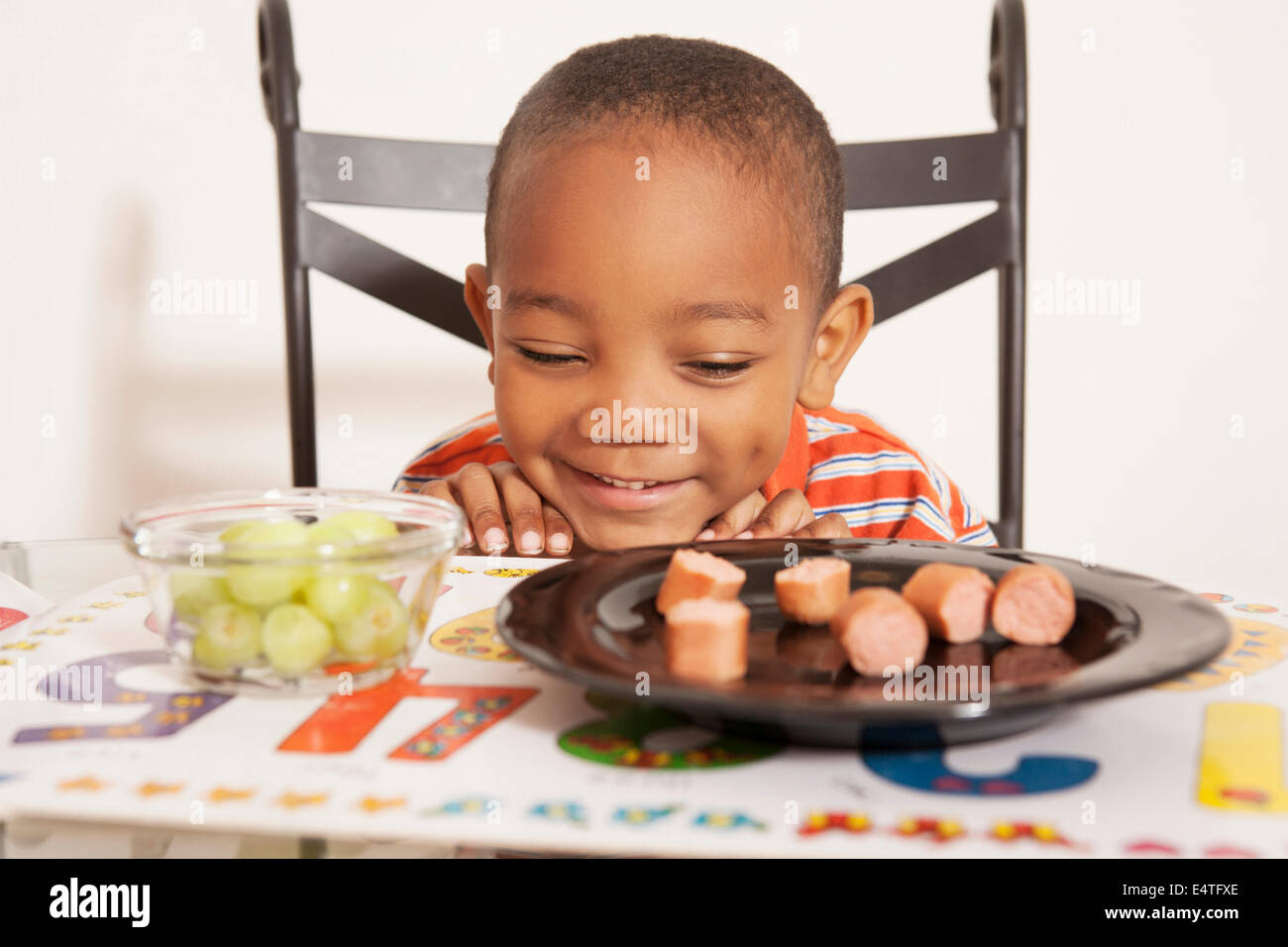 Boy Excited for Lunch, Sitting at Kitchen Table Stock Photo