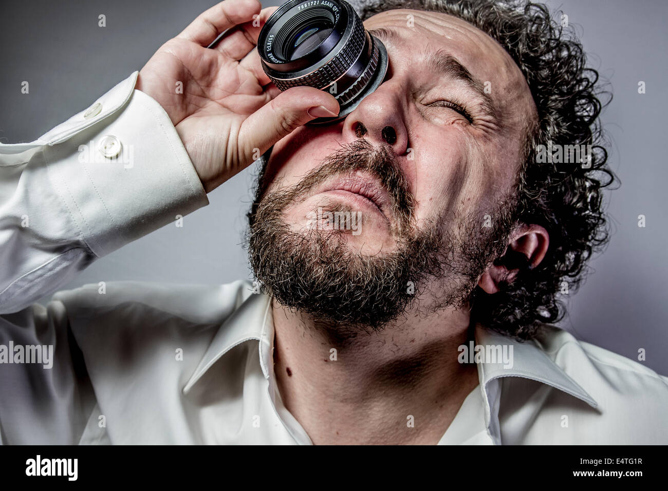 photographer with lens, man with intense expression, white shirt Stock