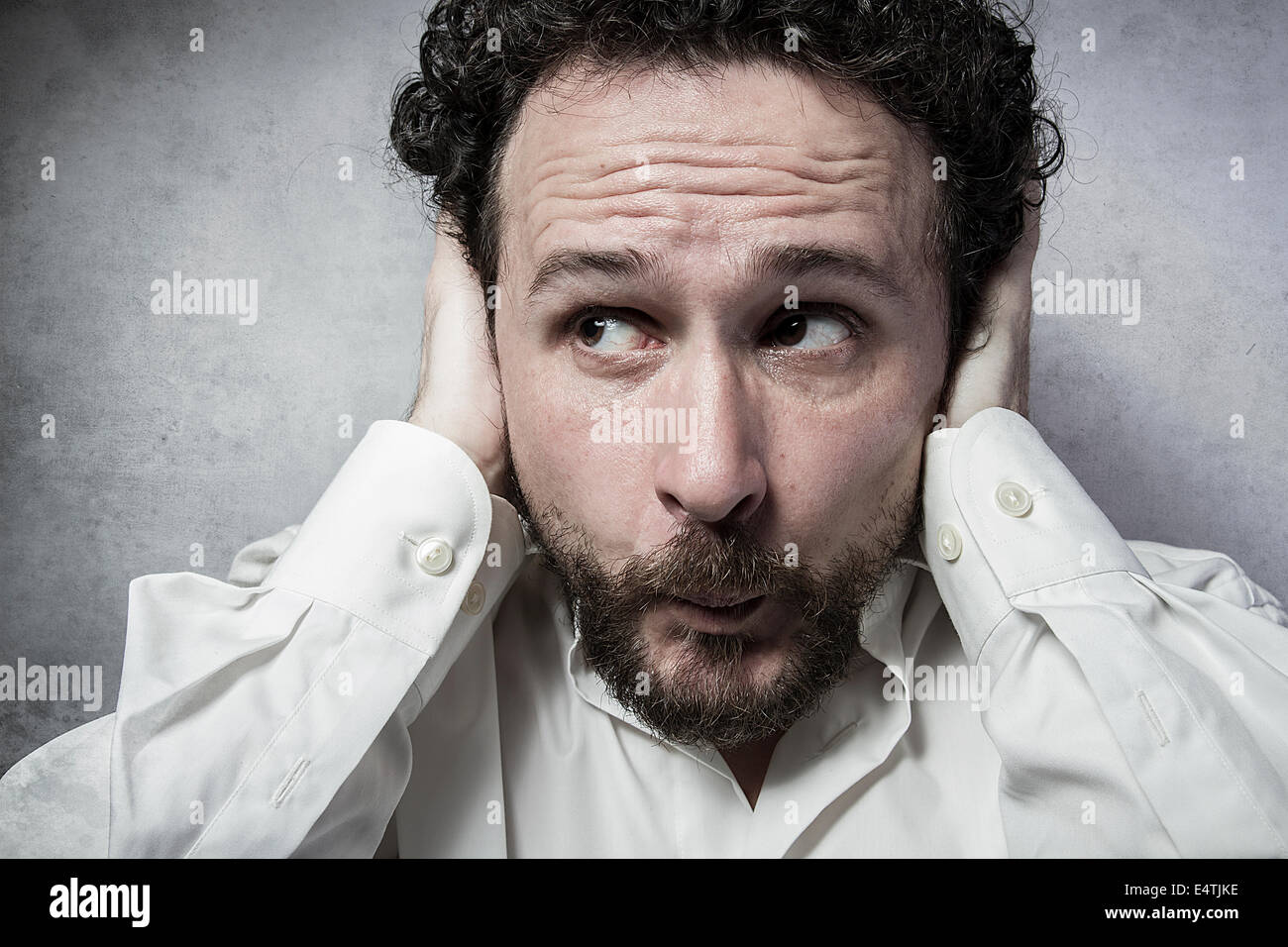Businessman covering his ears, man in white shirt with funny