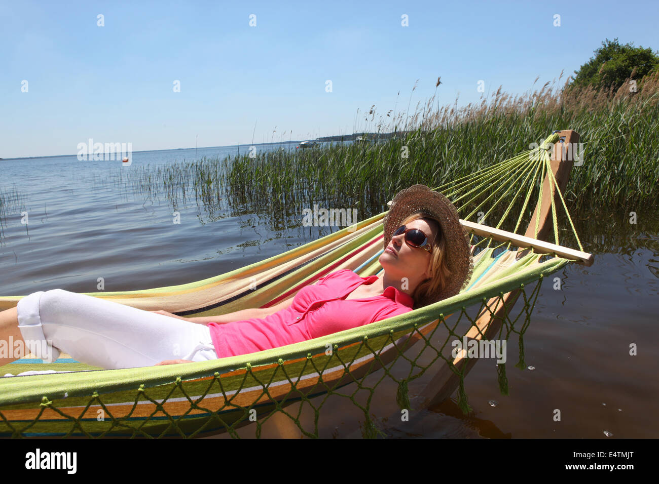 Woman in hammock by lake Stock Photo Alamy