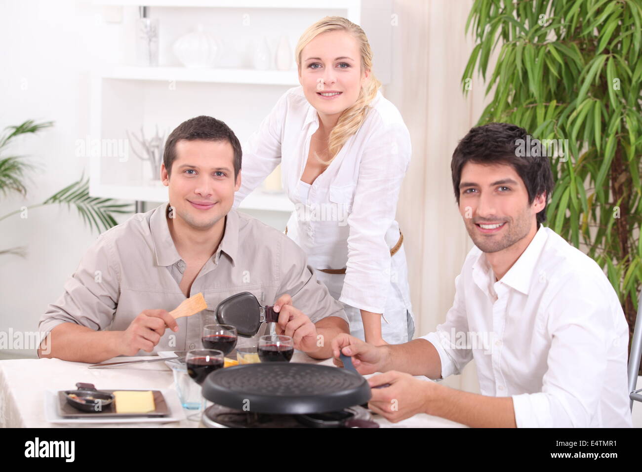 Friends eating raclette for dinner Stock Photo - Alamy