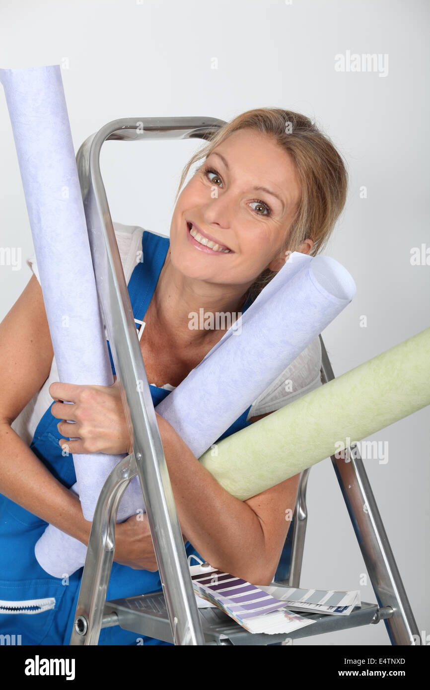 Woman  holding numerous wallpaper rolls Stock Photo