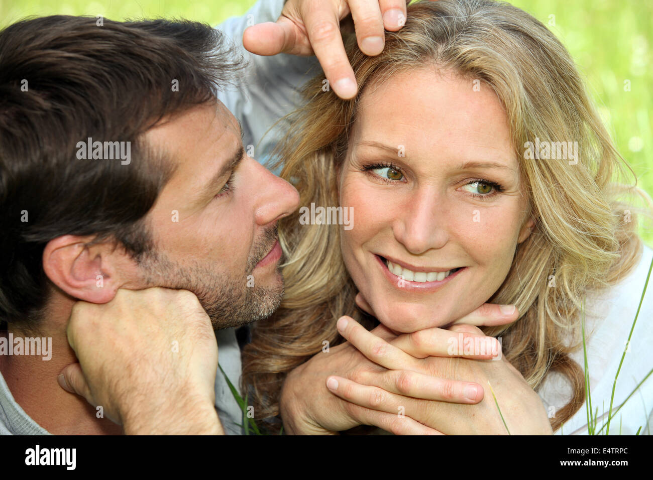 Couple in love lying in the grass Stock Photo - Alamy