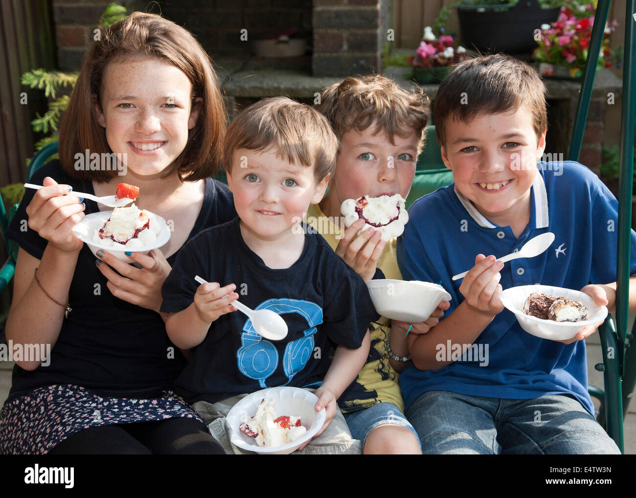 Children eating ice cream and cakes at a family party Stock Photo