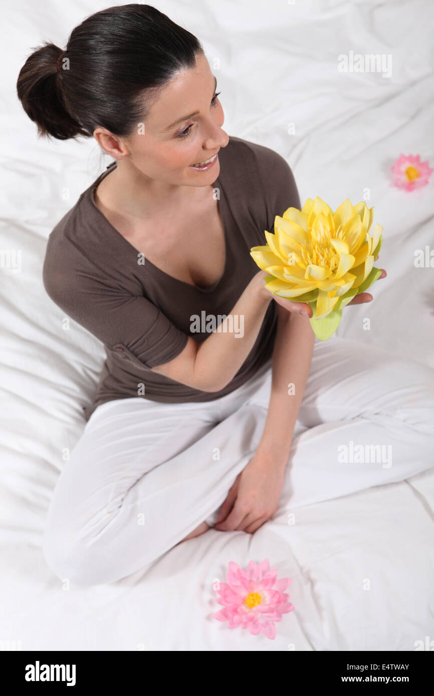 woman sitting cross-legged with water lily Stock Photo