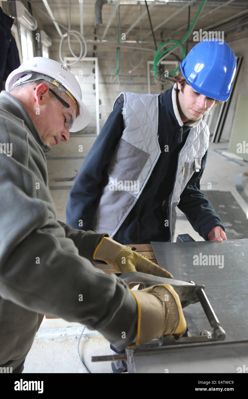 Two manual workers cutting sheet metal Stock Photo Alamy