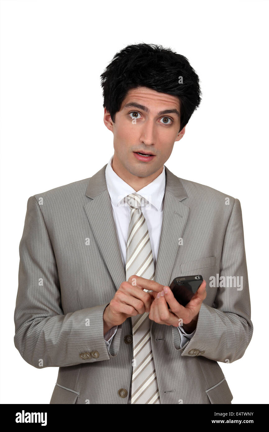 Wide eyed businessman sending a text message stock photo alamy