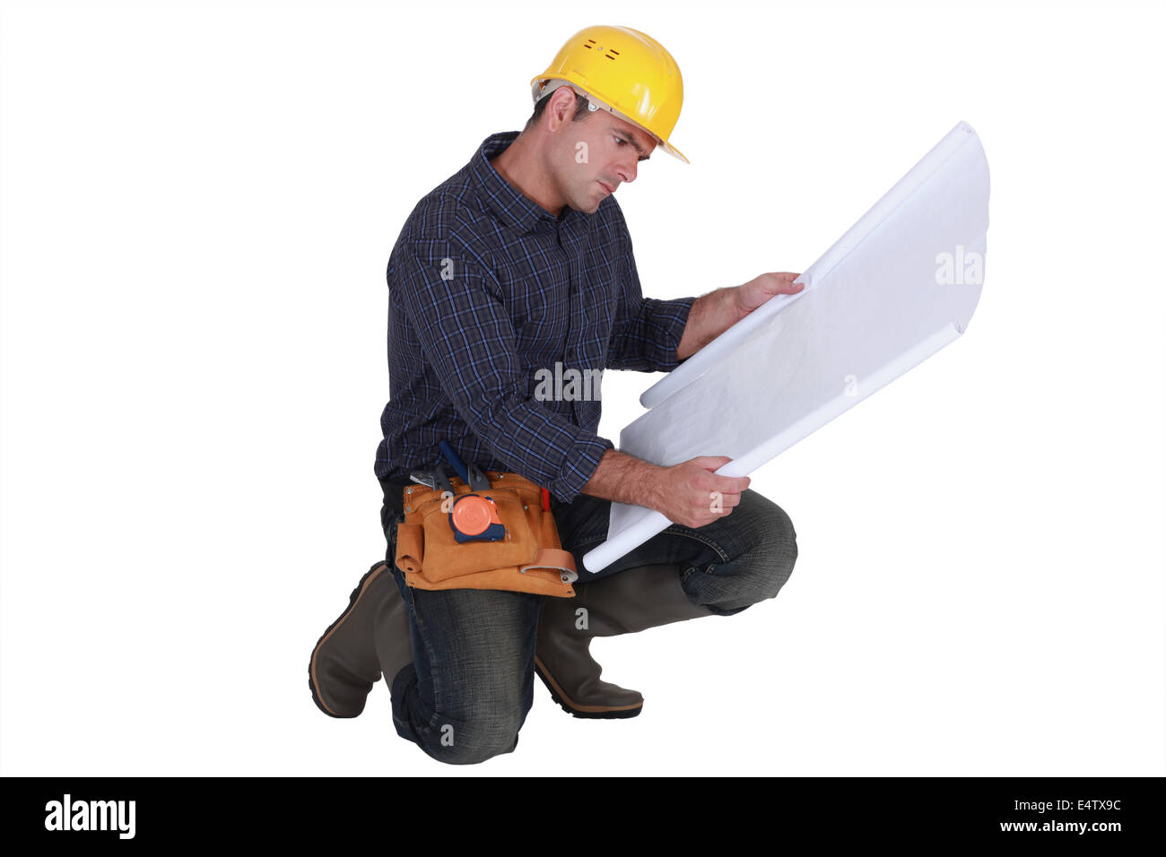 Frowning tradesman examining a blueprint Stock Photo