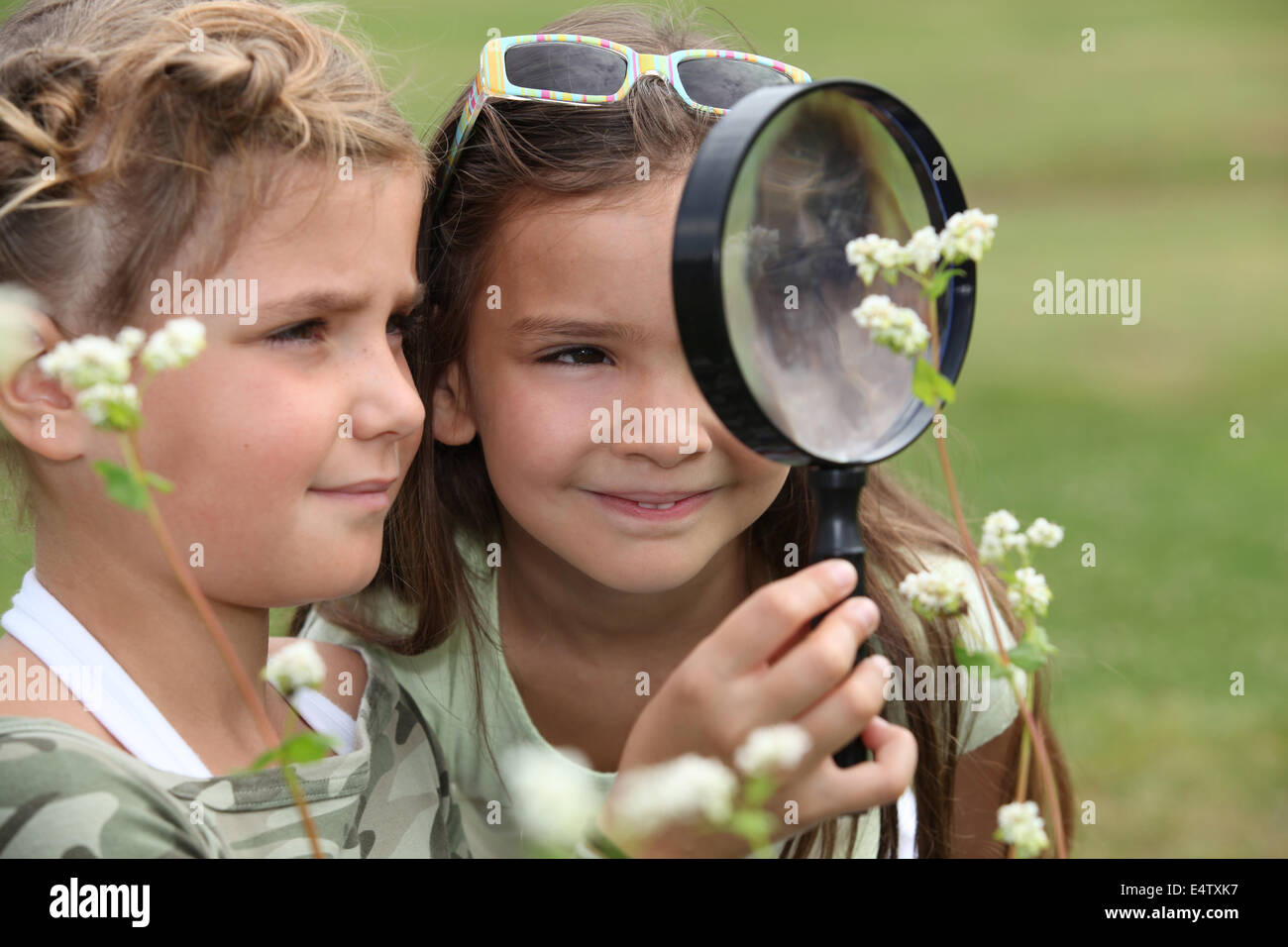Two little girls with magnifying glasses Stock Photo