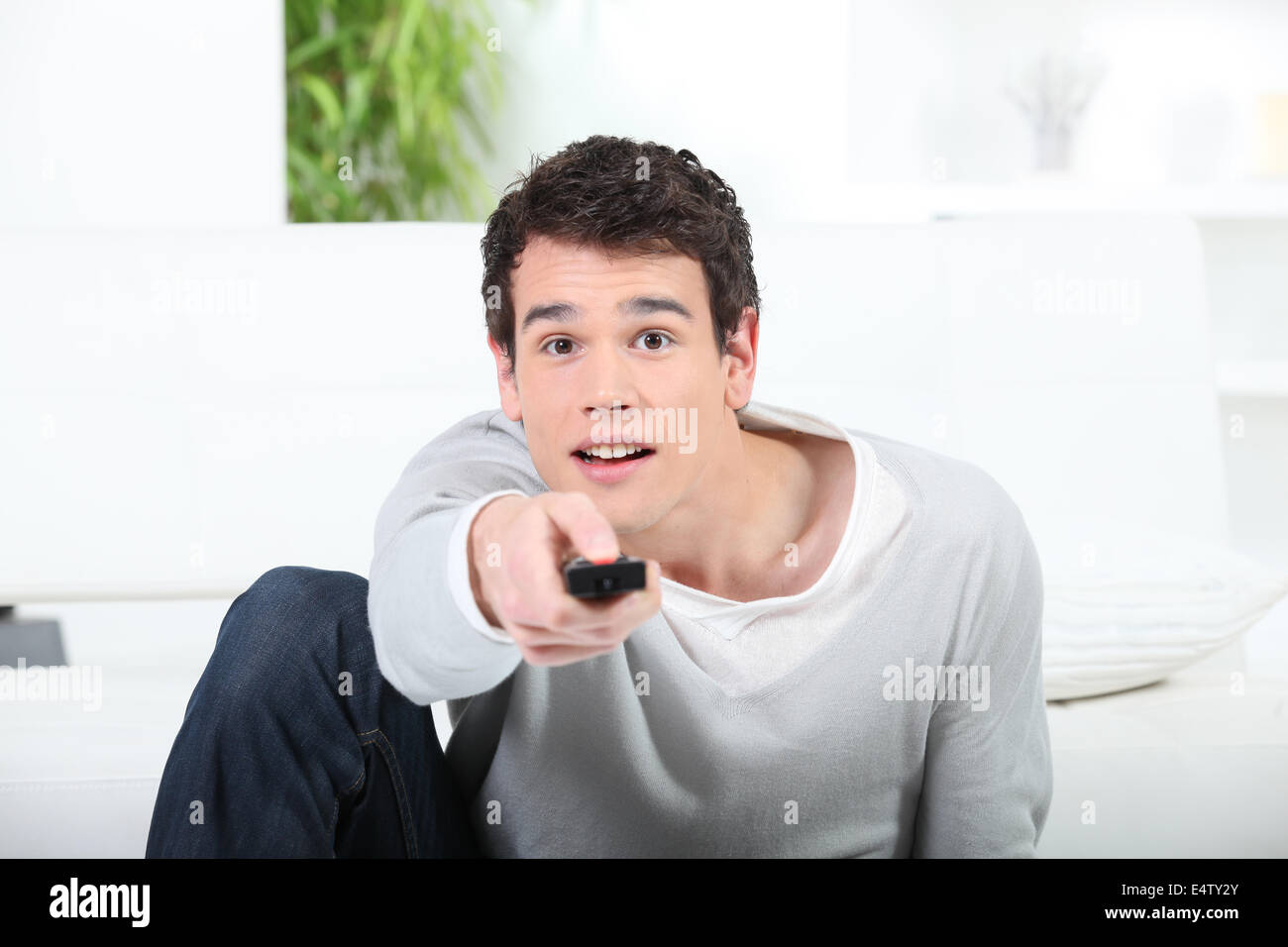 Man with television remote Stock Photo - Alamy