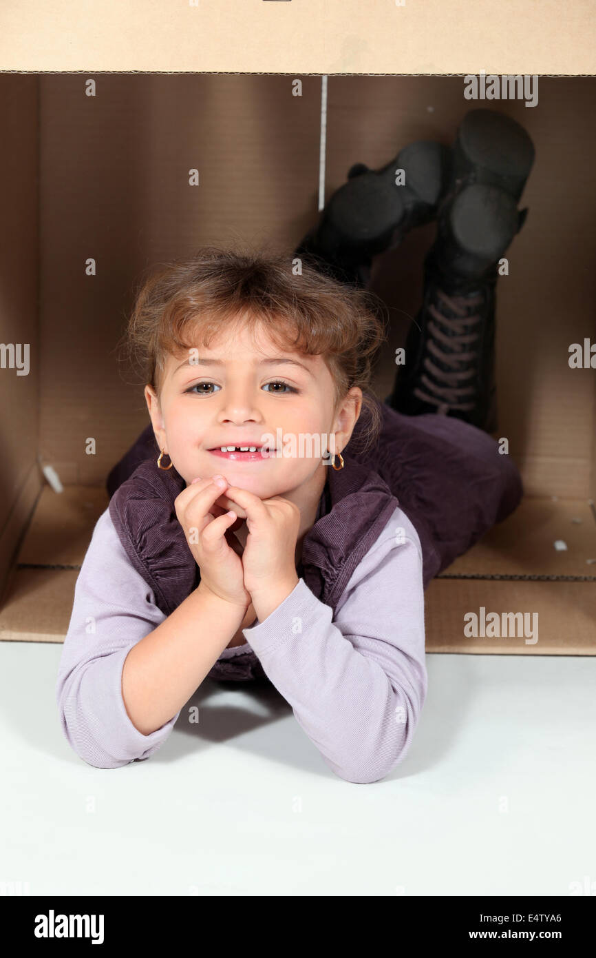 Little girl lying in a cardboard box Stock Photo