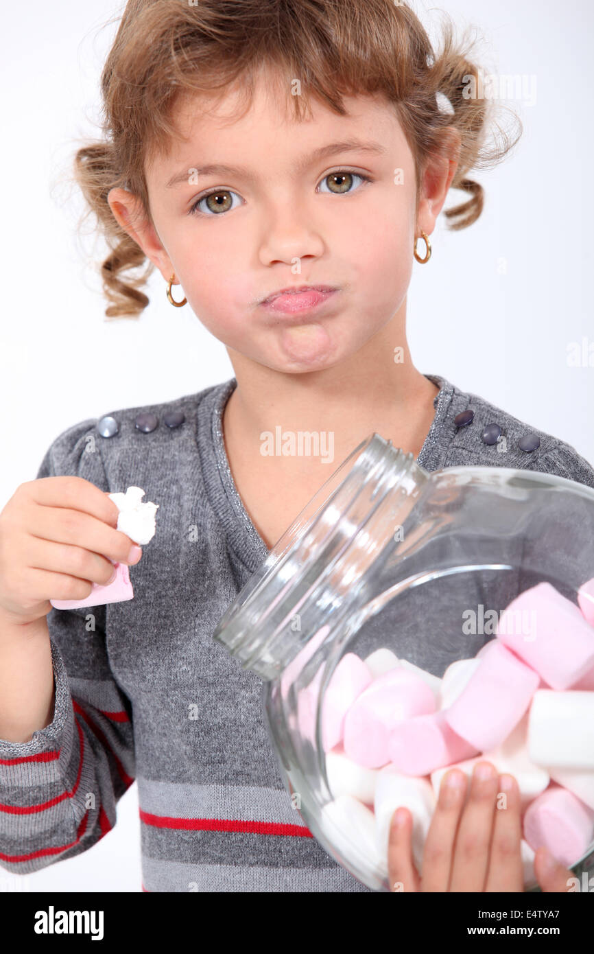 Little girl eating marshmallows from a jar Stock Photo Alamy
