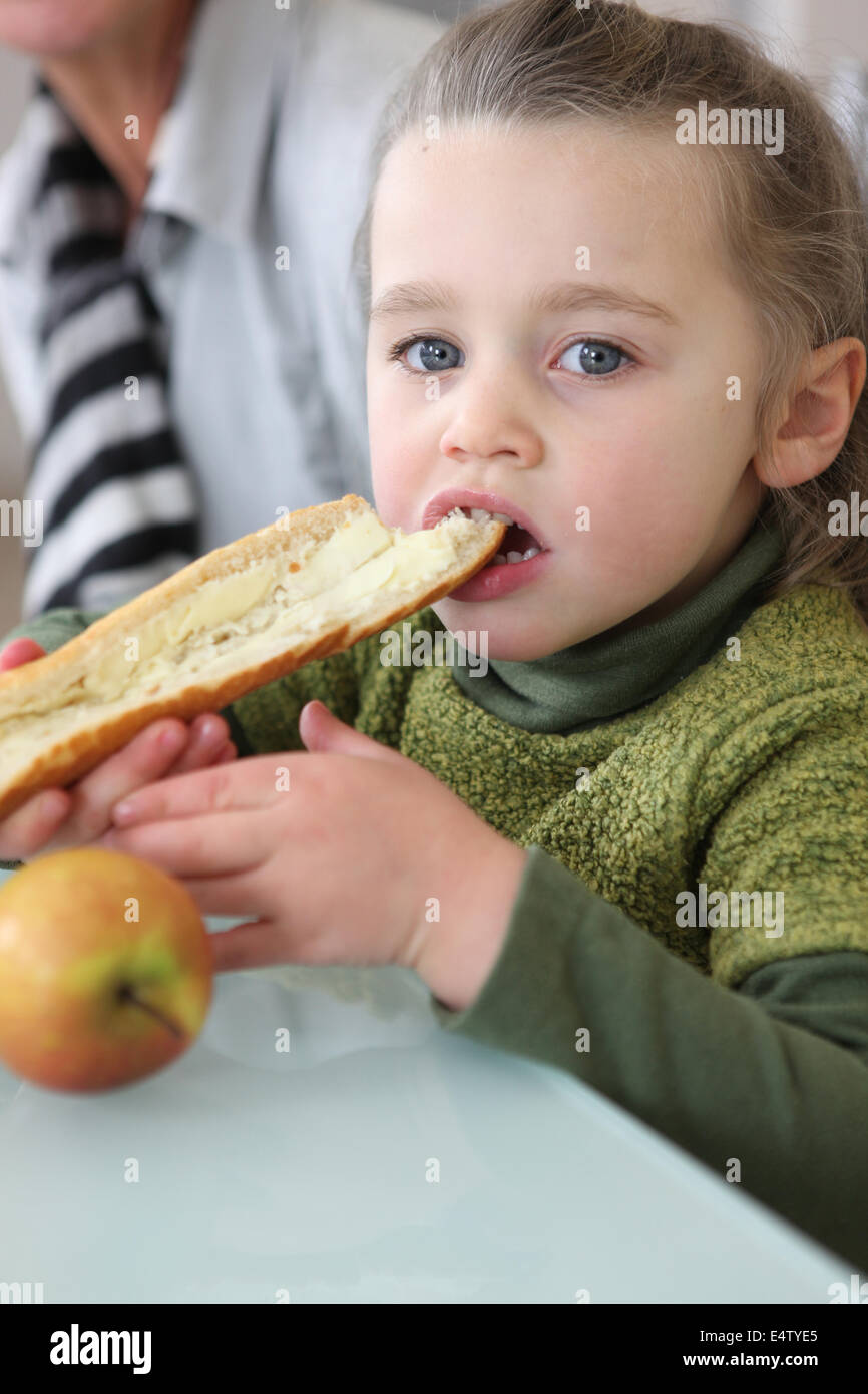 Girl eating slice of buttered bread Stock Photo Alamy