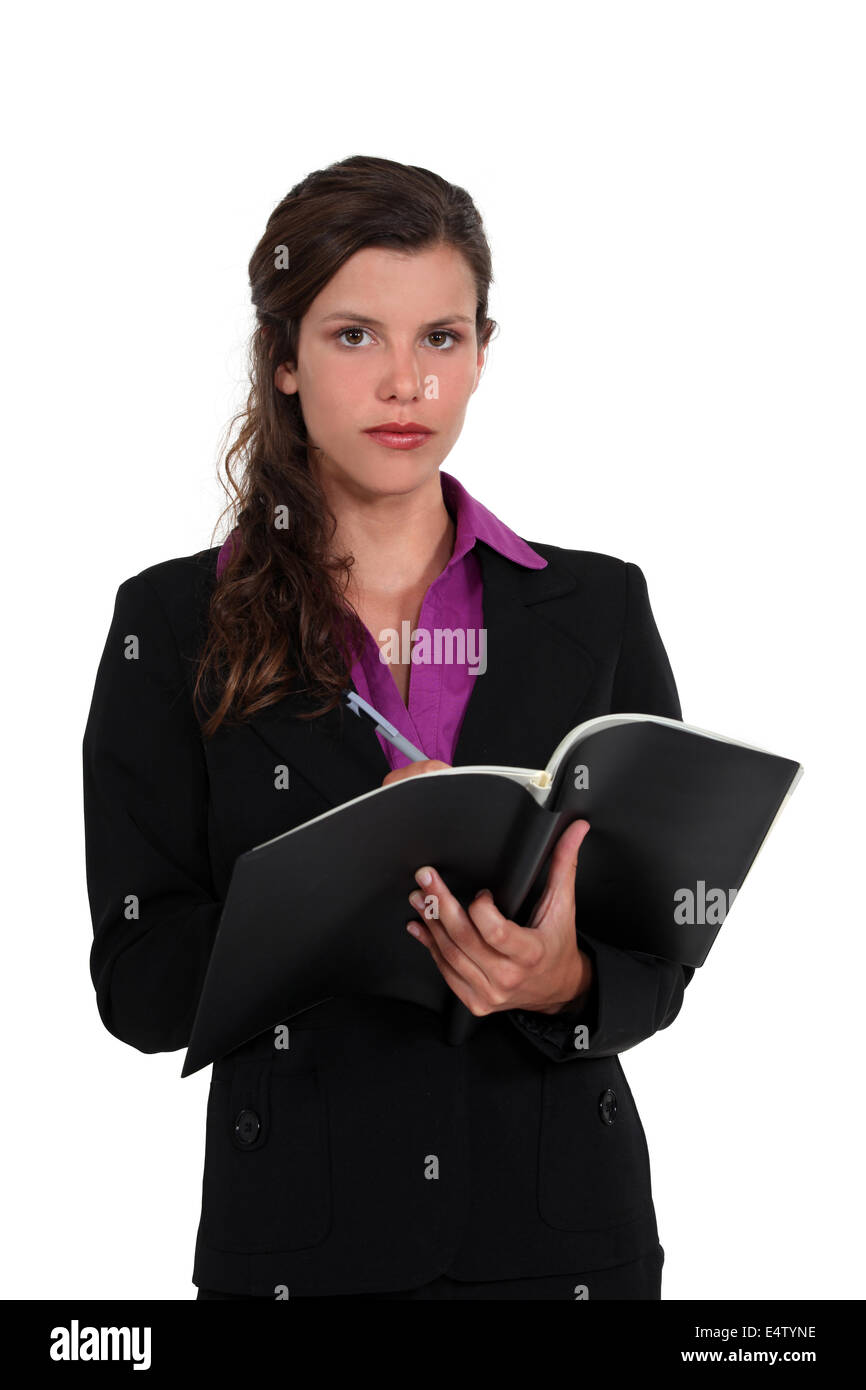 Businesswoman writing in her agenda Stock Photo