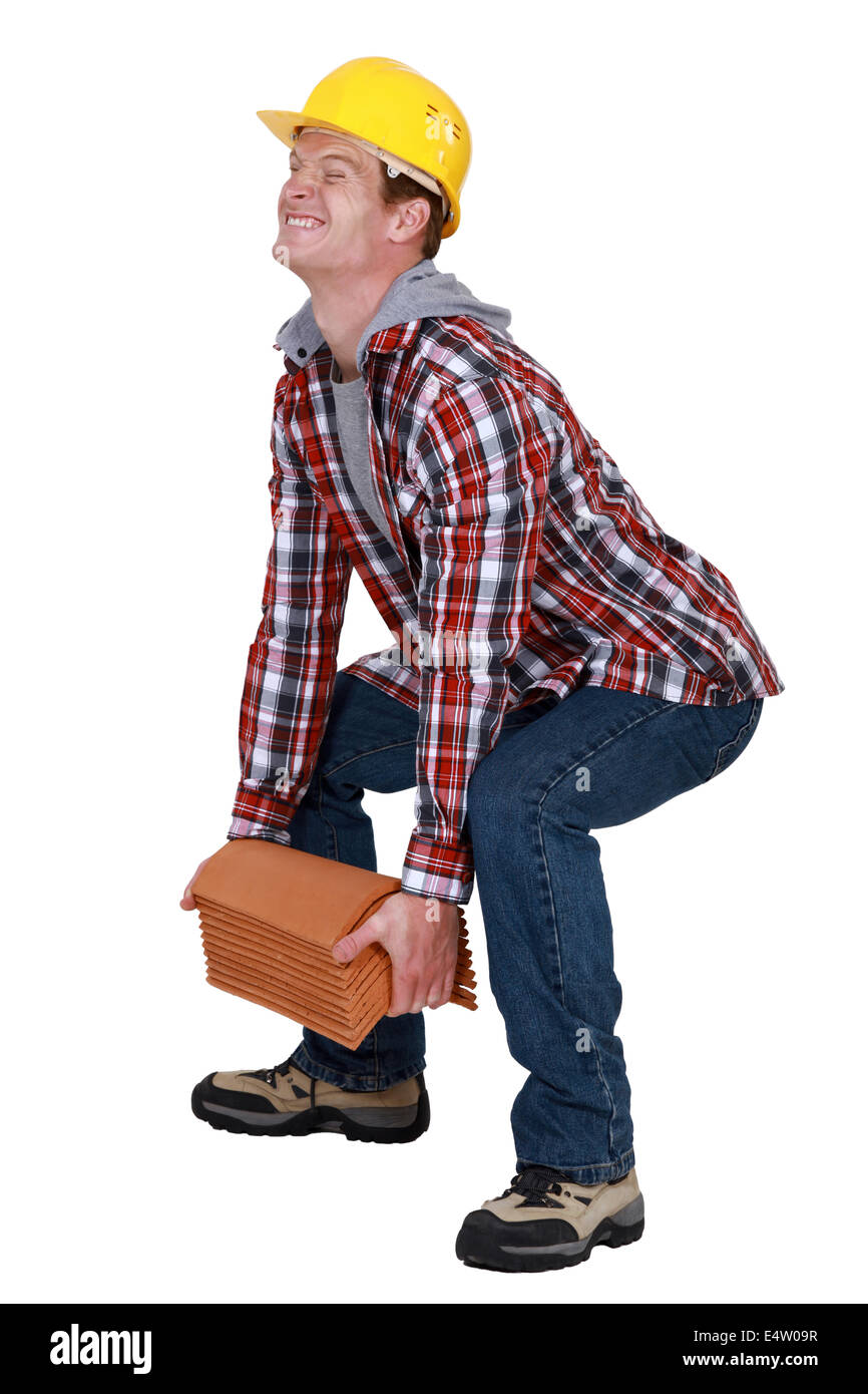 Tradesman lifting a heavy load Stock Photo