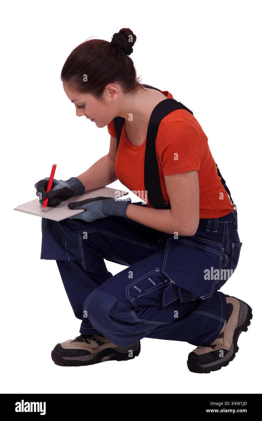 Woman measuring tile before cutting Stock Photo Alamy