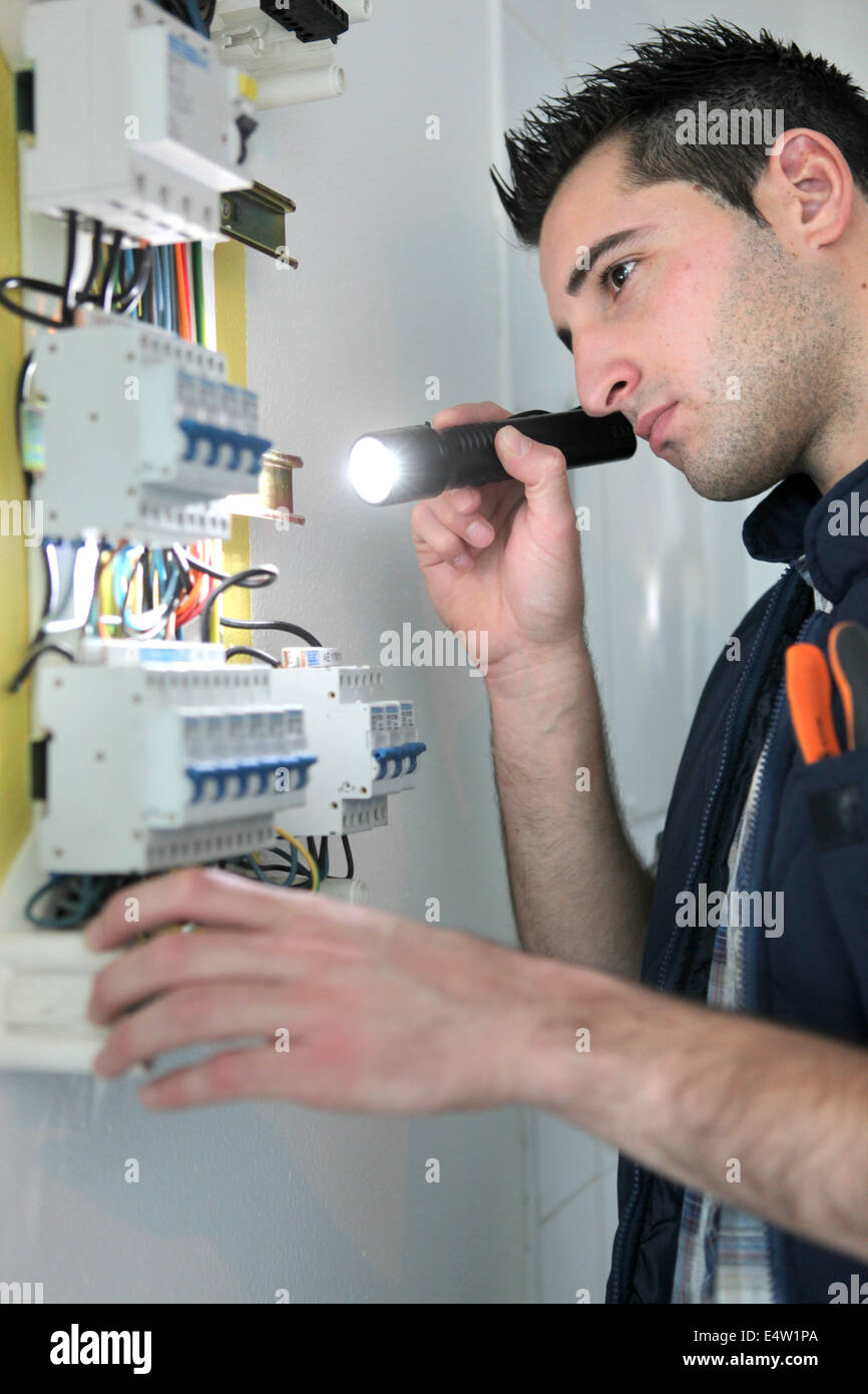 Electrician examining fuse box Stock Photo