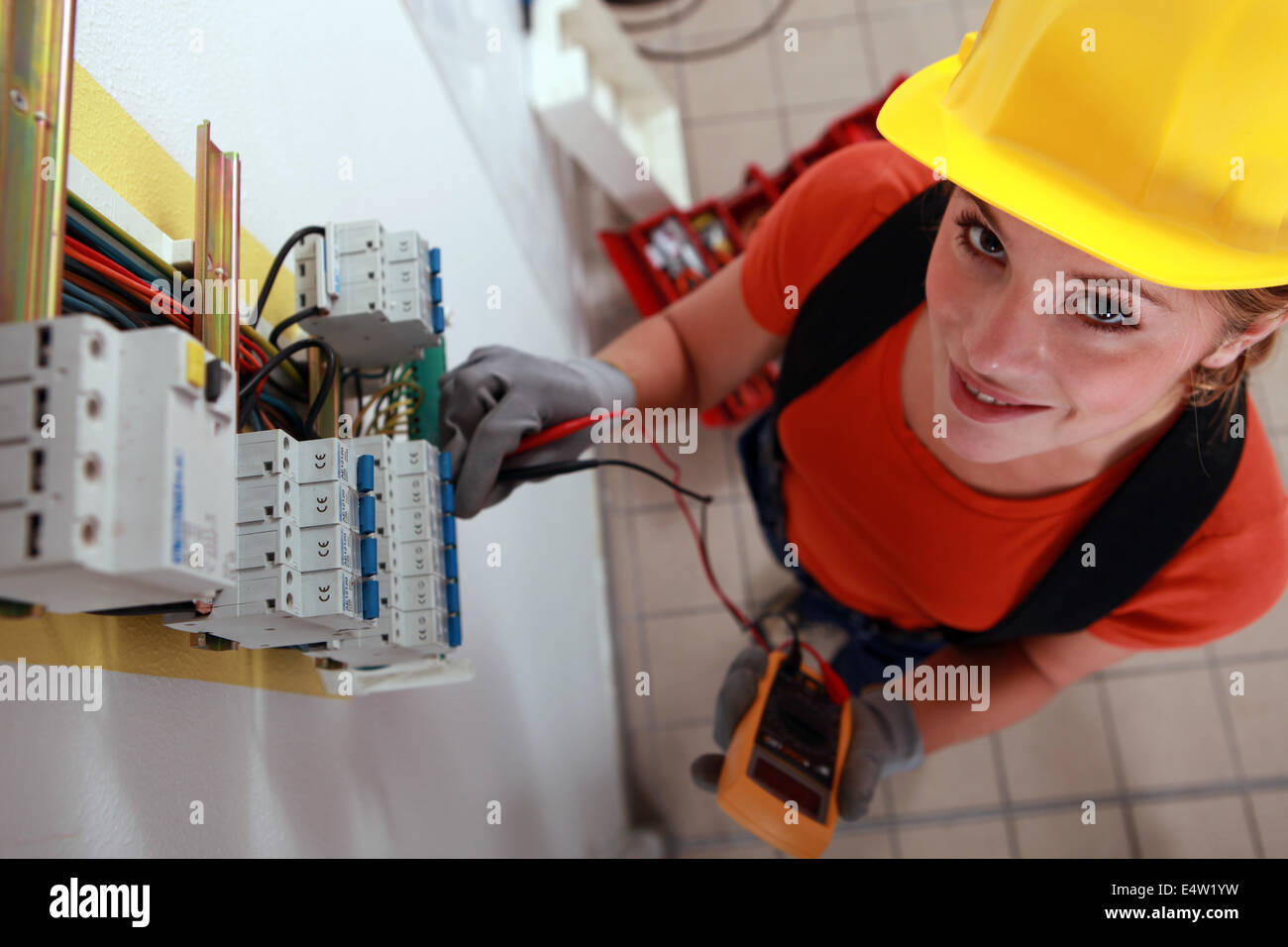 Female electrician checking fuse box Stock Photo