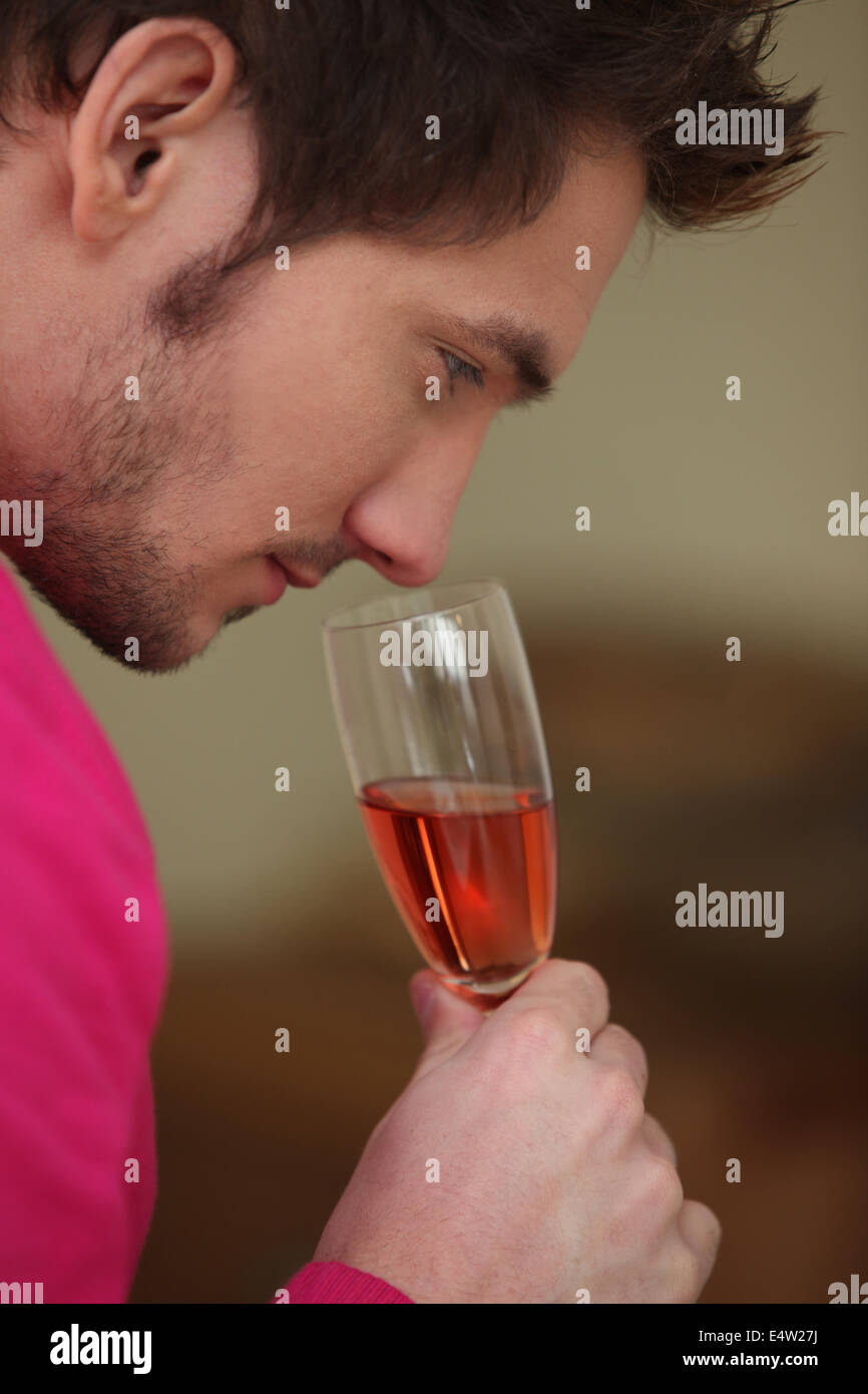 Young man smelling a glass of wine Stock Photo - Alamy