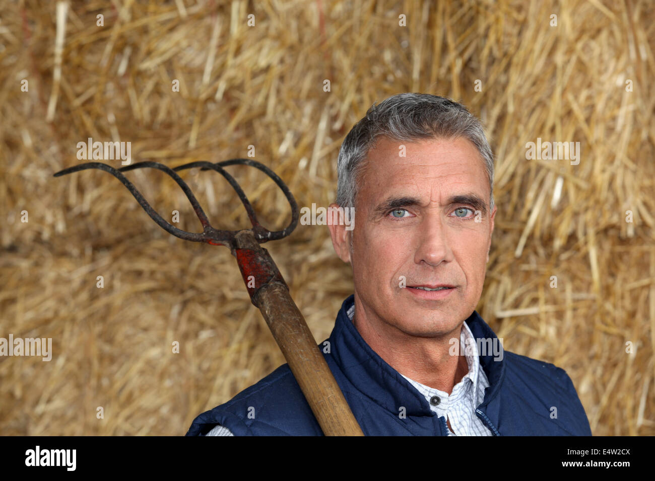 Farmer holding a pitchfork Stock Photo