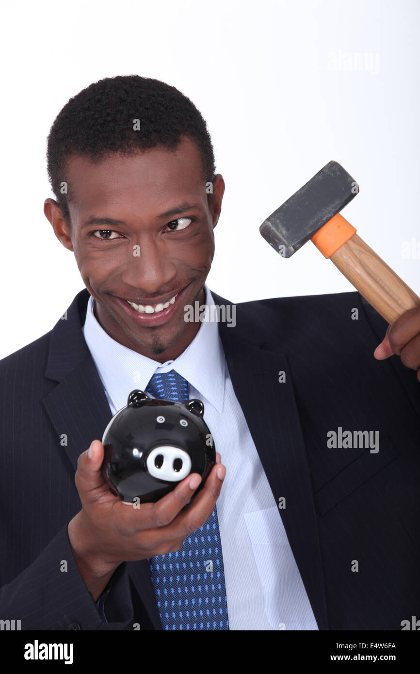 Man hammering open a piggy bank Stock Photo - Alamy