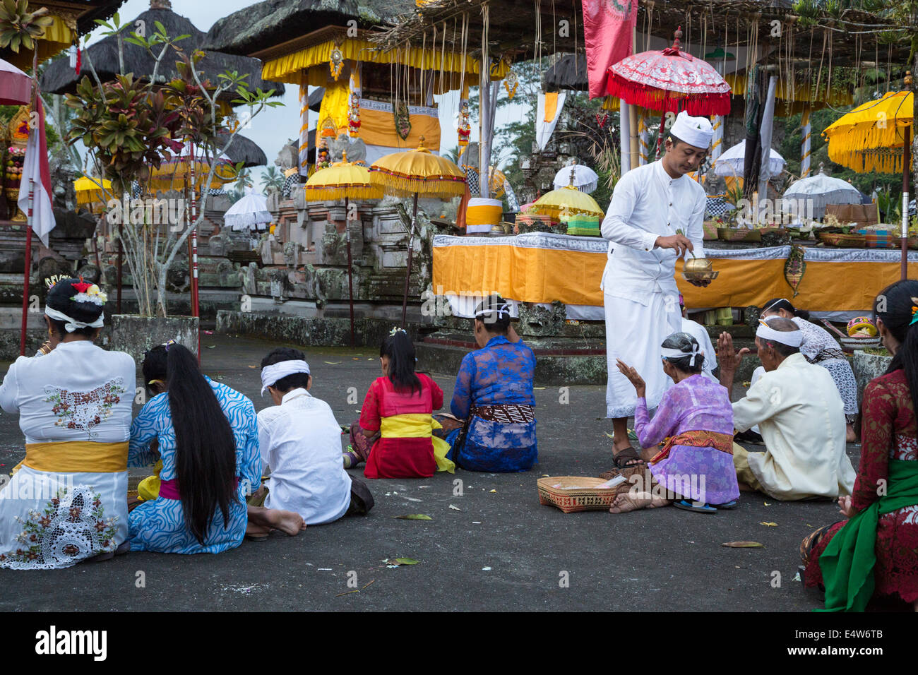 Bali, Indonesia. Hindu Priest Blessing Worshipers with Holy Water. Pura