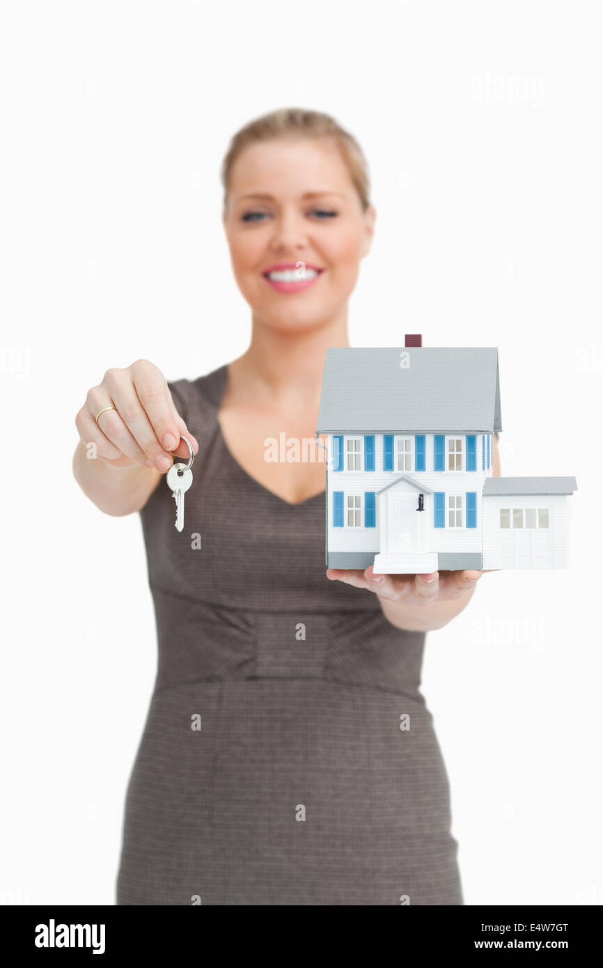 Woman showing a key and a model house Stock Photo - Alamy