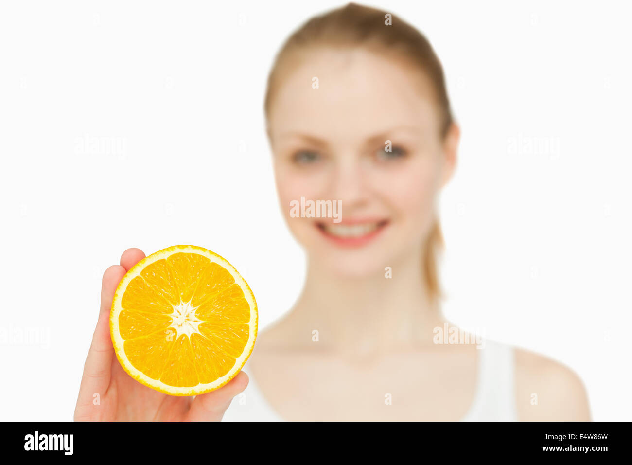 Smiling woman holding an orange Stock Photo - Alamy