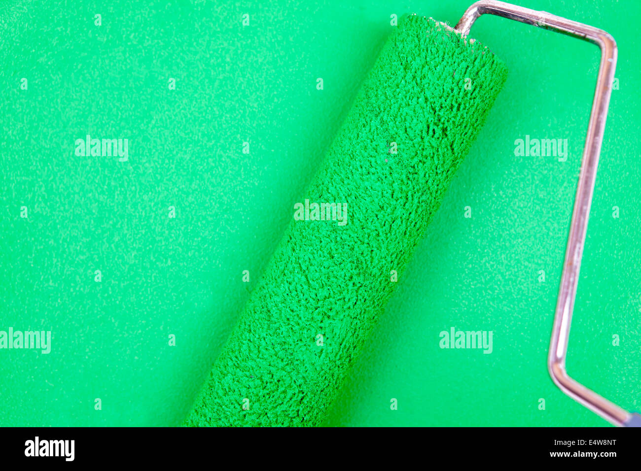 Green background with a paint roller Stock Photo - Alamy