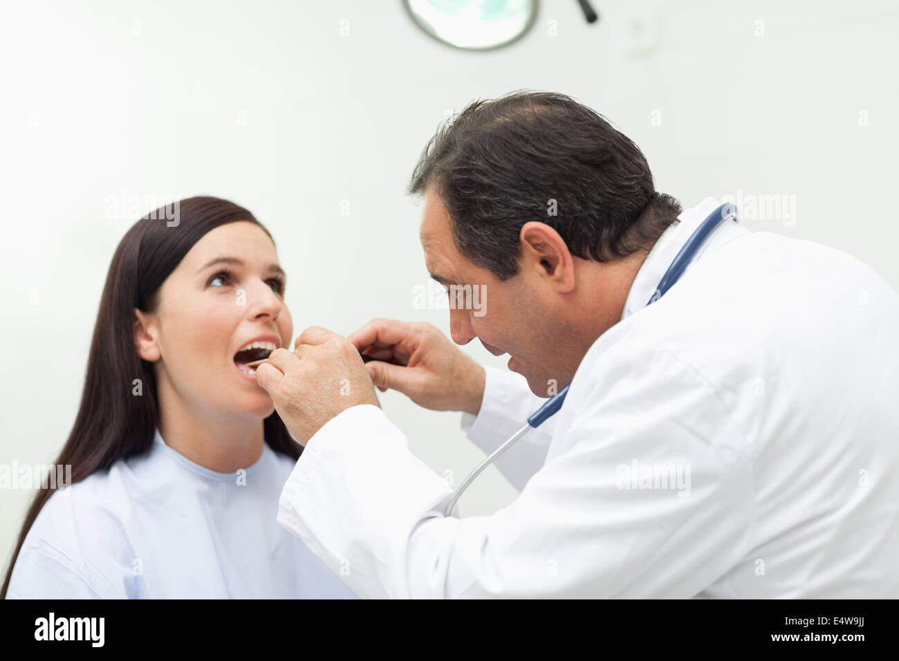 Doctor looking at the mouth of his patient Stock Photo