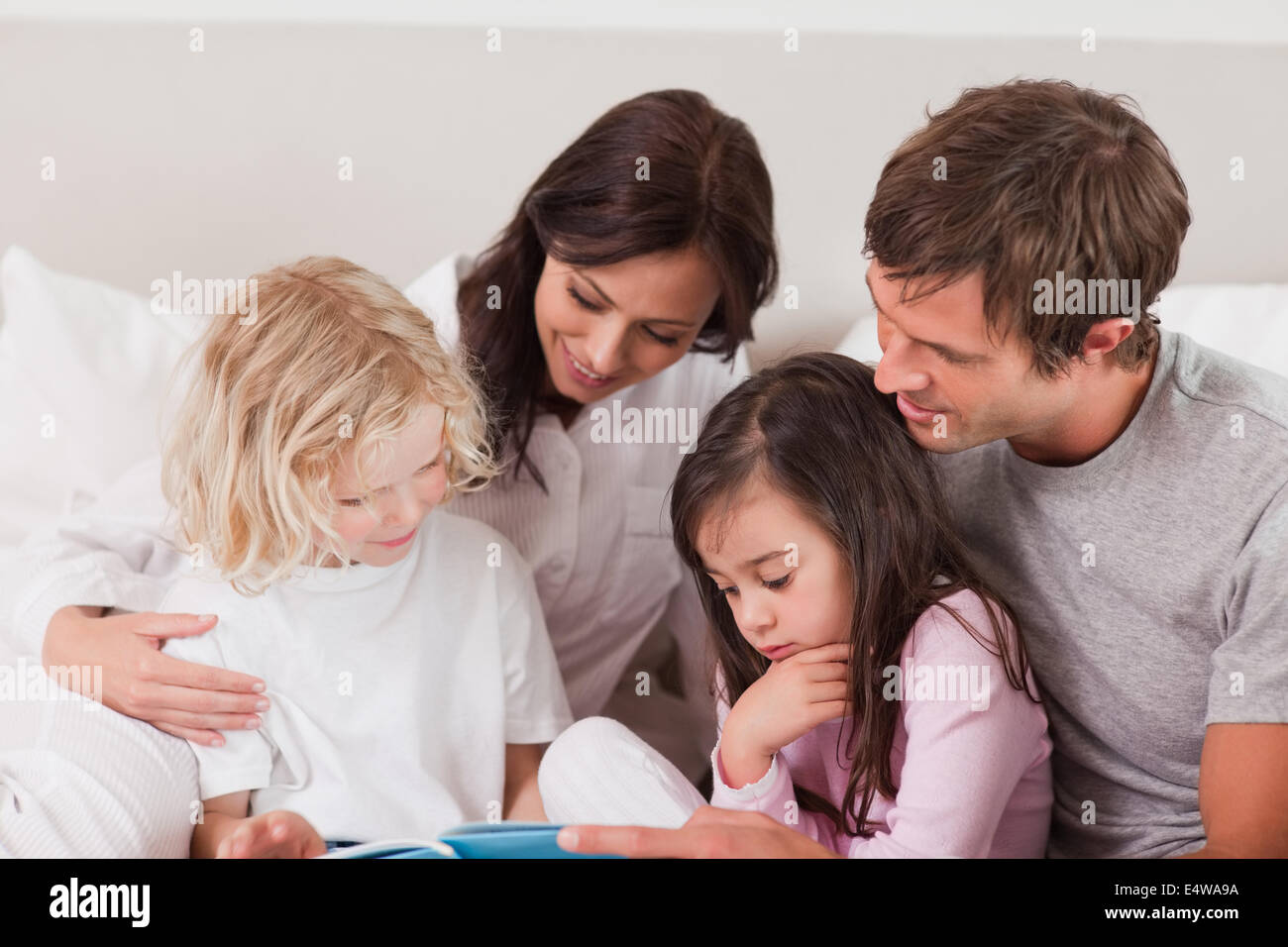 Lovely family reading a book Stock Photo - Alamy
