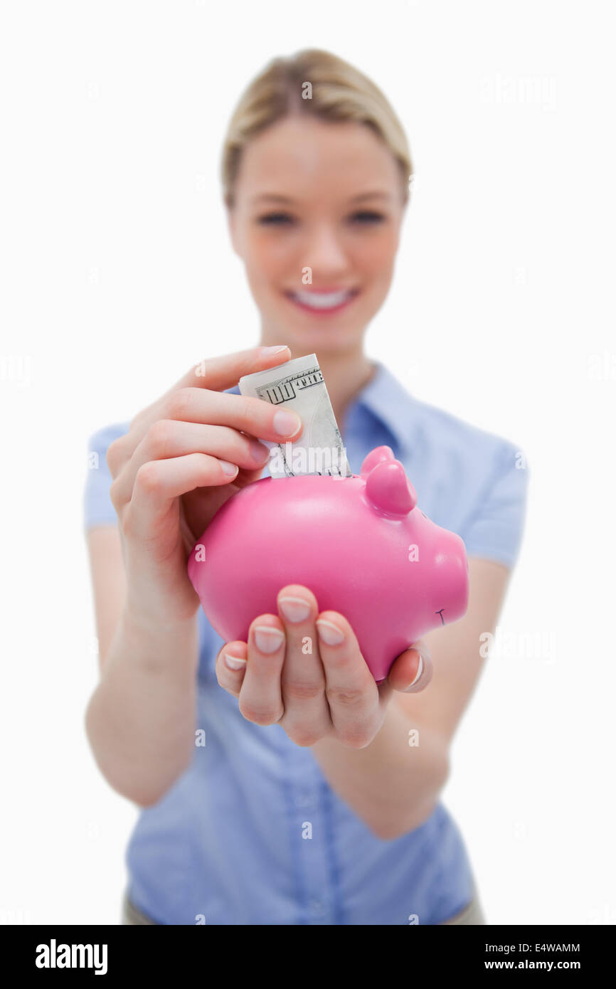 Money being put into piggy bank by woman Stock Photo - Alamy