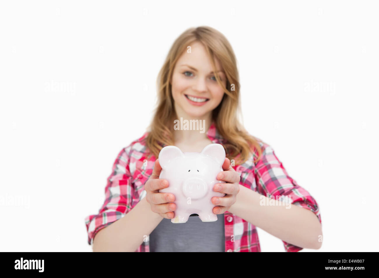 Woman holding a piggy bank while smiling Stock Photo - Alamy