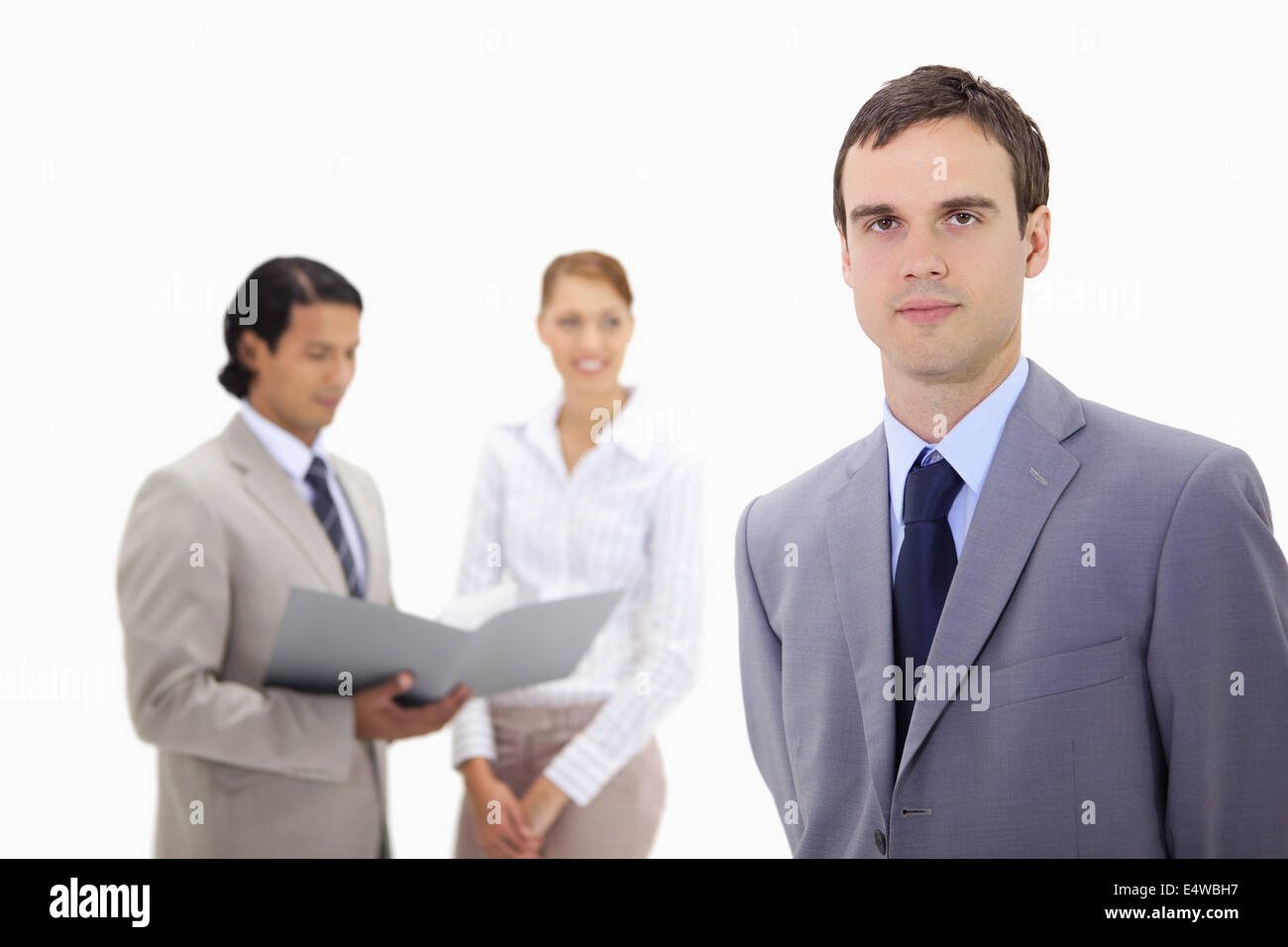 Young businessman with colleagues behind him Stock Photo - Alamy