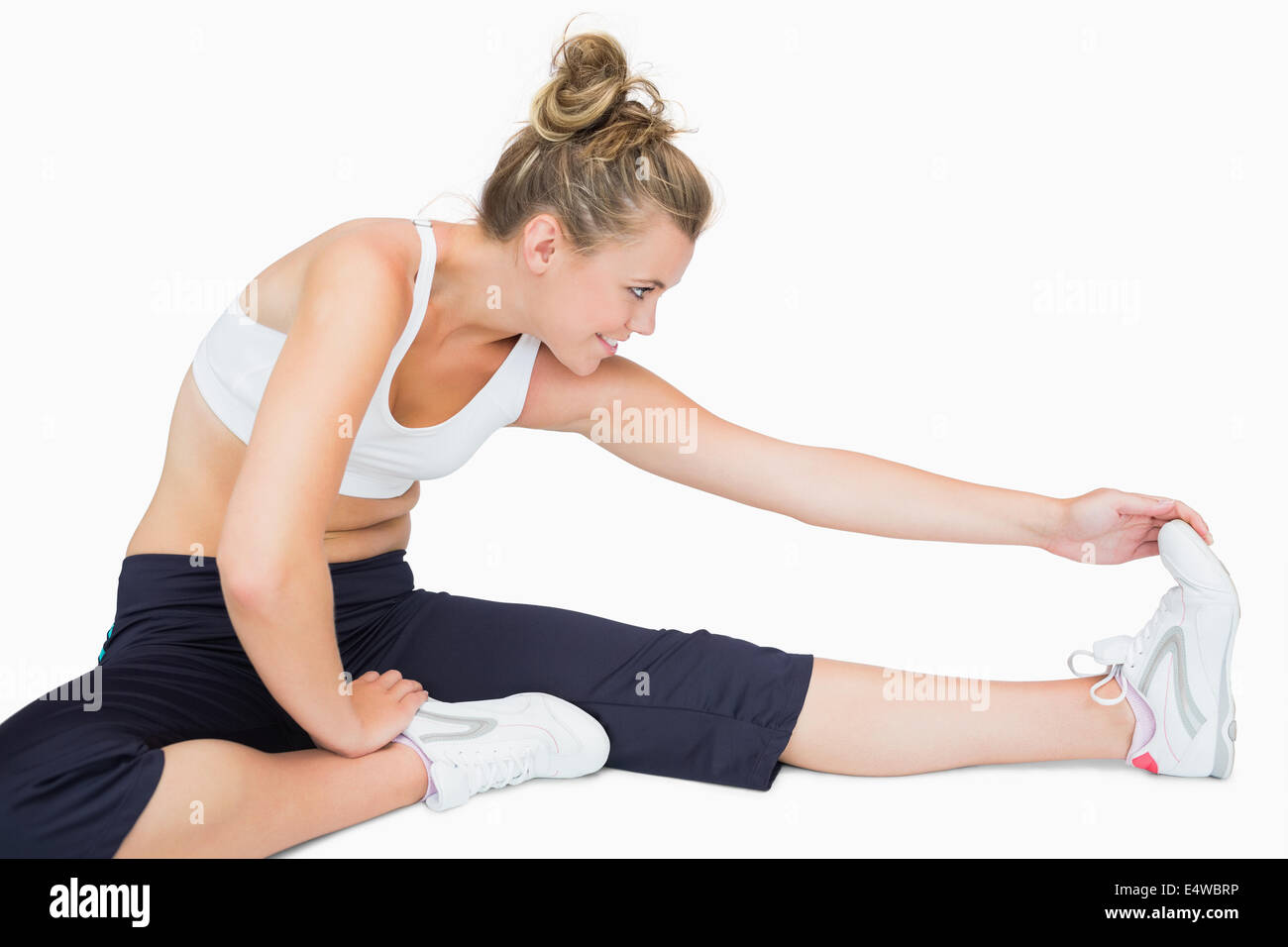 Woman sitting while stretching leg Stock Photo - Alamy