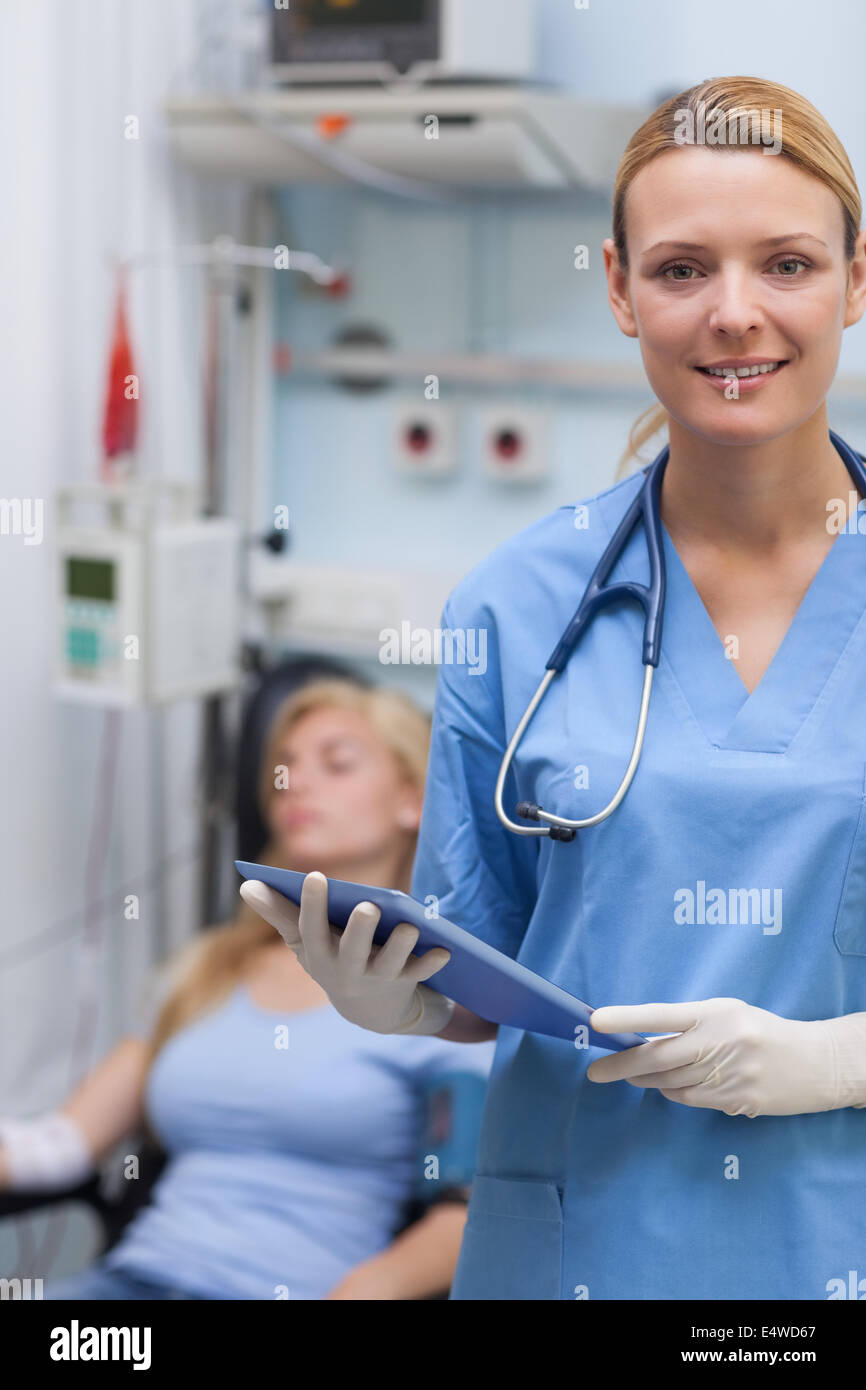 Nurse holding a clipboard next to a patient Stock Photo - Alamy