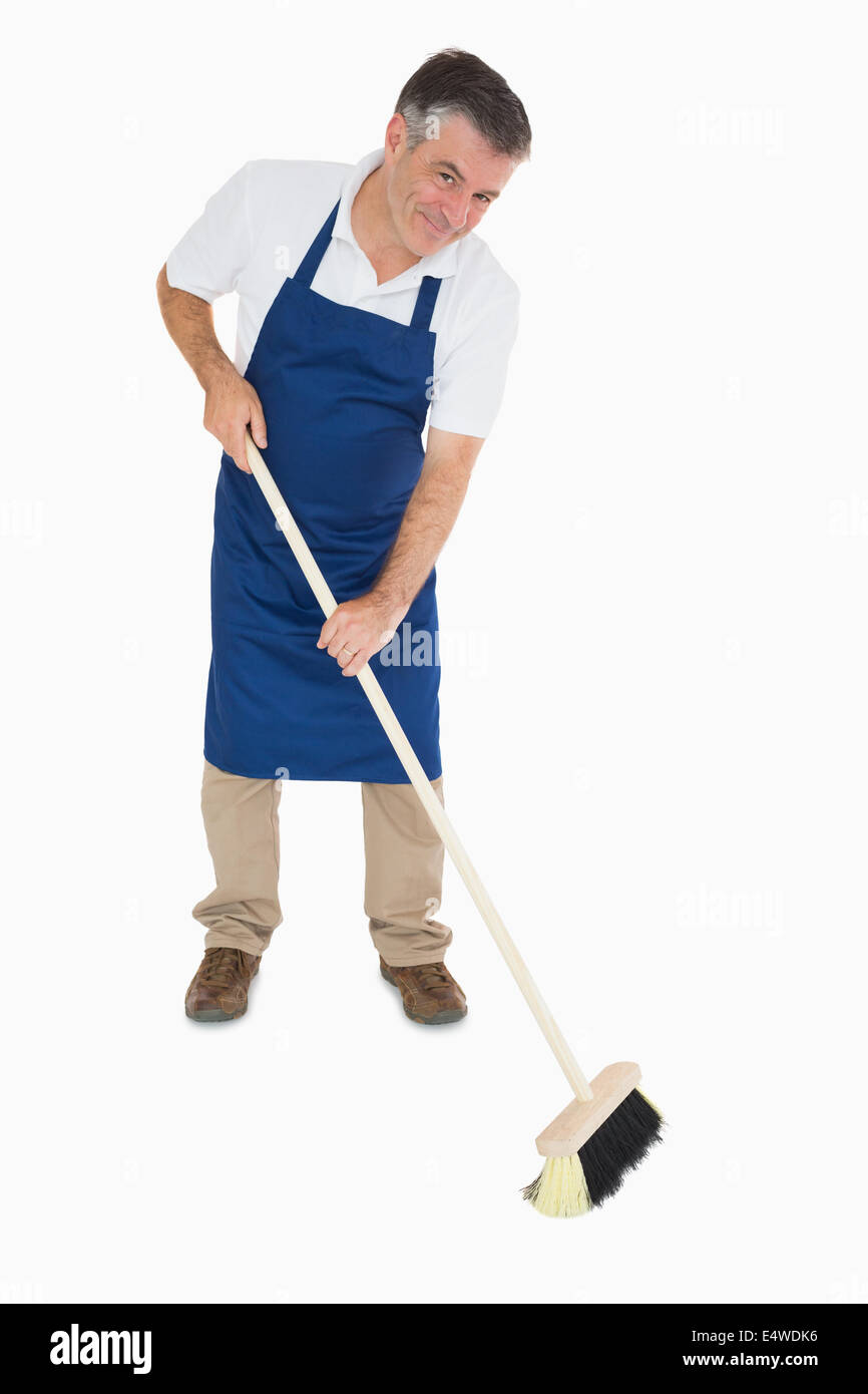 Happy man sweeping floor Stock Photo