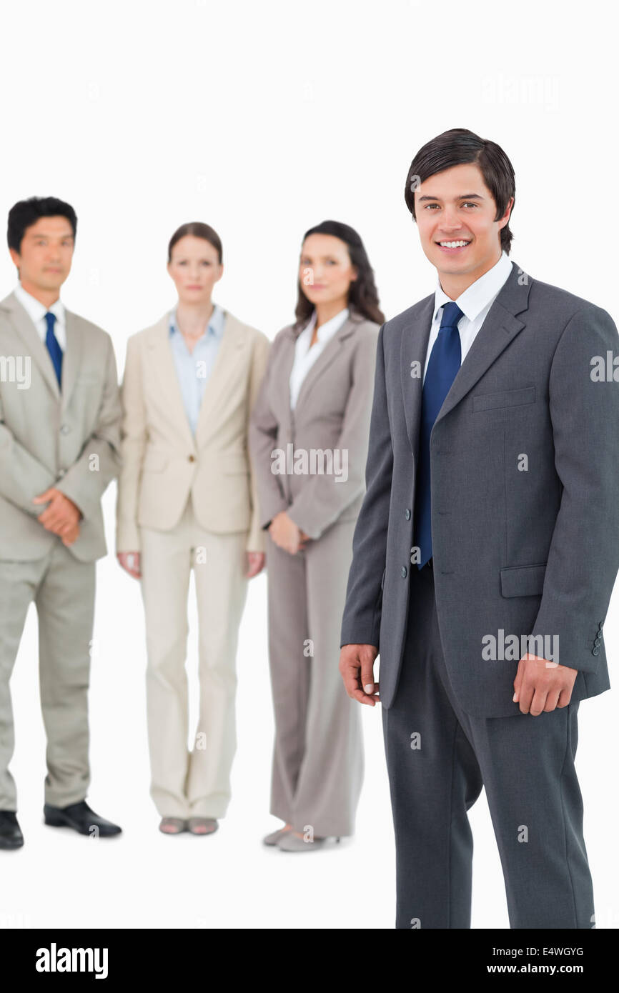 Smiling young salesman with team behind him Stock Photo - Alamy