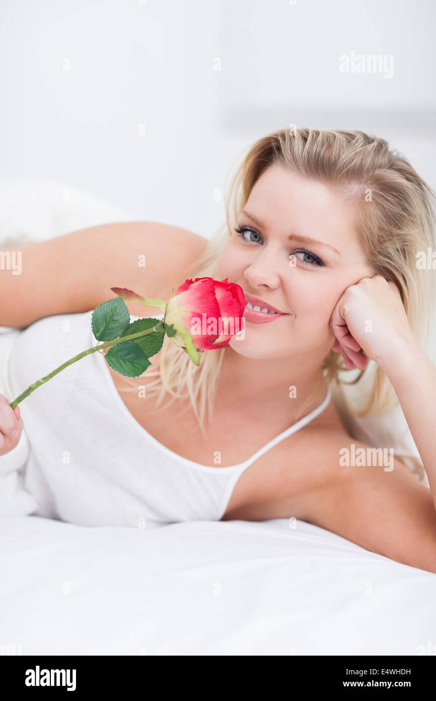 Young woman smelling a pink rose Stock Photo - Alamy