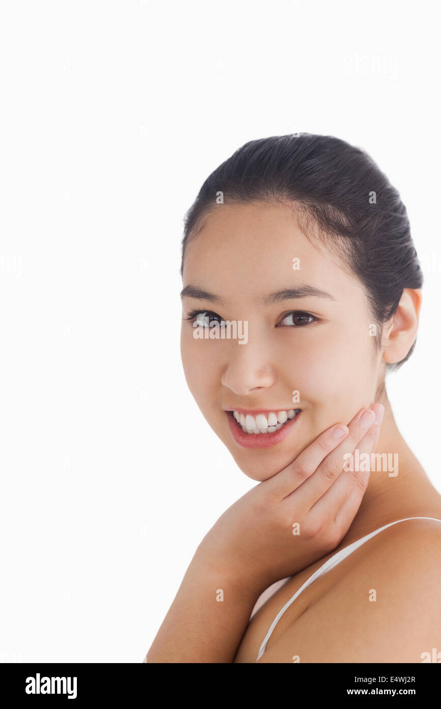 Woman smiling while touching face Stock Photo - Alamy