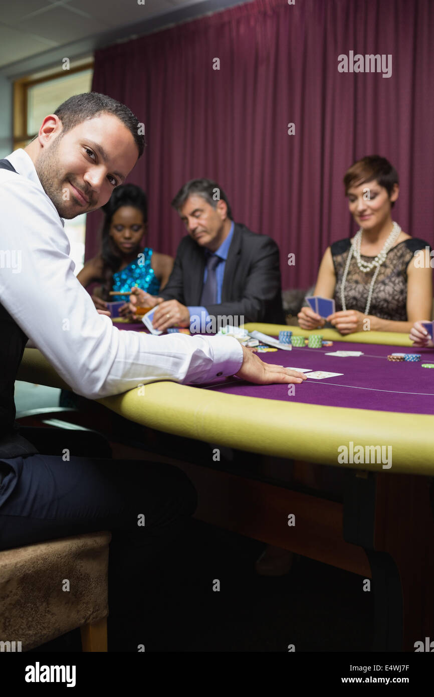 Smiling dealer at poker game Stock Photo