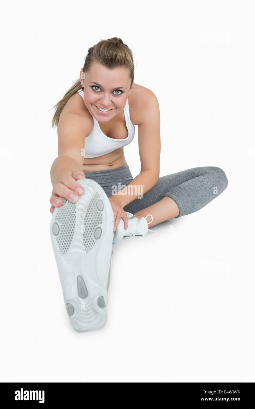 Smiling woman stretching her leg Stock Photo - Alamy