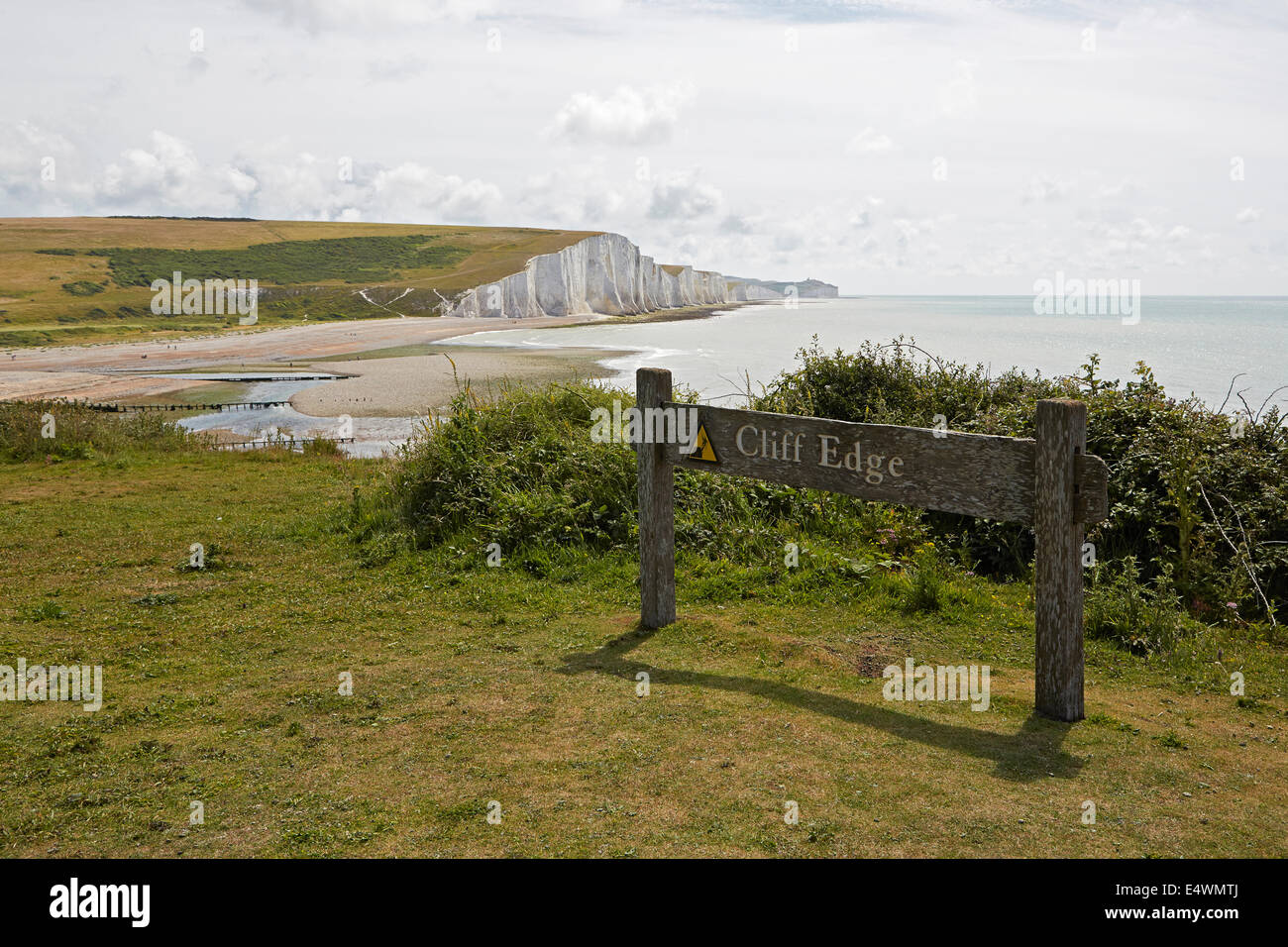 Cuckmere Haven and the Seven Sisters with dangerous cliff edge sign viewed from the coast guard cottages Stock Photo