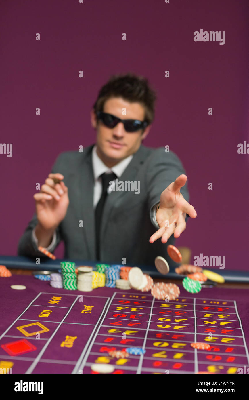Man throwing chips on roulette table Stock Photo Alamy